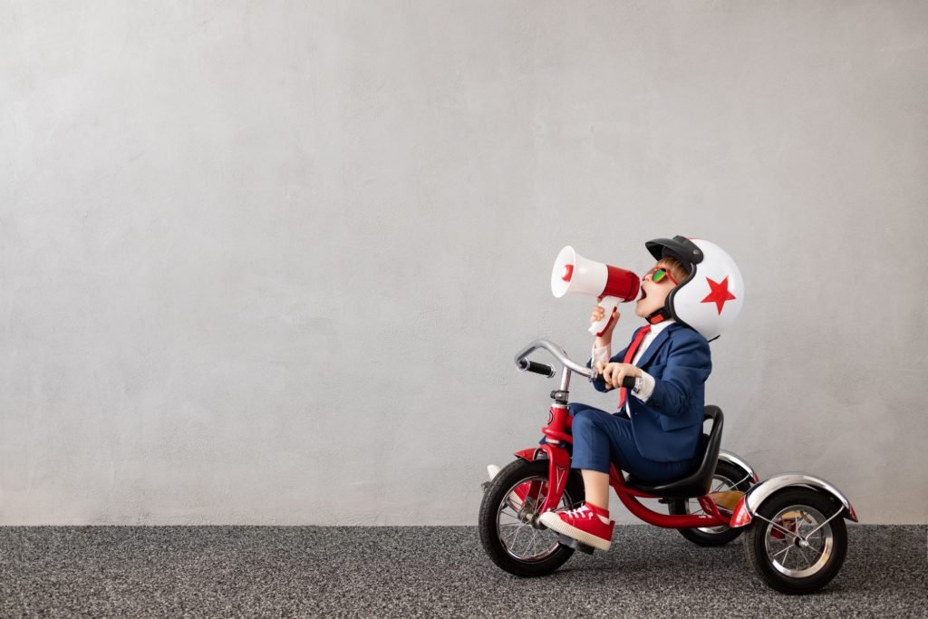 Happy child wearing suit riding vintage bicycle